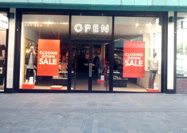 shop called Open displaying closing down sale posters